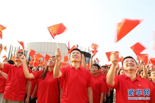 9月26日，在廣東東莞民盈·國貿中心，粵港澳青年揮舞國旗，合唱《歌唱祖國》。新華社記者 李嘉樂 攝