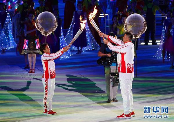 10月18日，第七屆世界軍人運動會開幕式在武漢體育中心舉行。這是火炬手王霜（左）與火炬手劉玉棟在開幕式上交接。新華社記者 金良快 攝