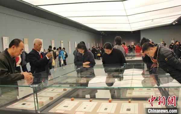 圖為觀眾在展廳內欣賞篆刻作品。　趙曉 攝