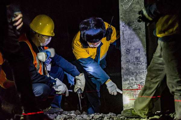 機械工隊長侯寧與03506清篩車組車隊長核對清篩后的線路標高，嚴把施工質量關。（攝影 賈佳）