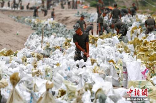 資料圖：7月25日，江西省九江市柴桑區(qū)江洲鎮(zhèn)北堤，中國人民解放軍第71集團(tuán)軍某部官兵正在為防洪備料。