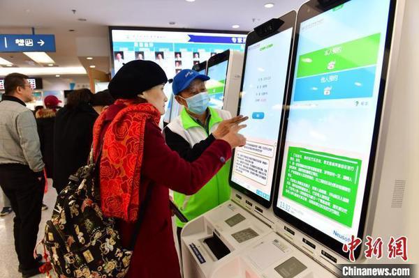資料圖：一位患者在指導下使用人臉識別系統預約專家號。　王廣兆 攝